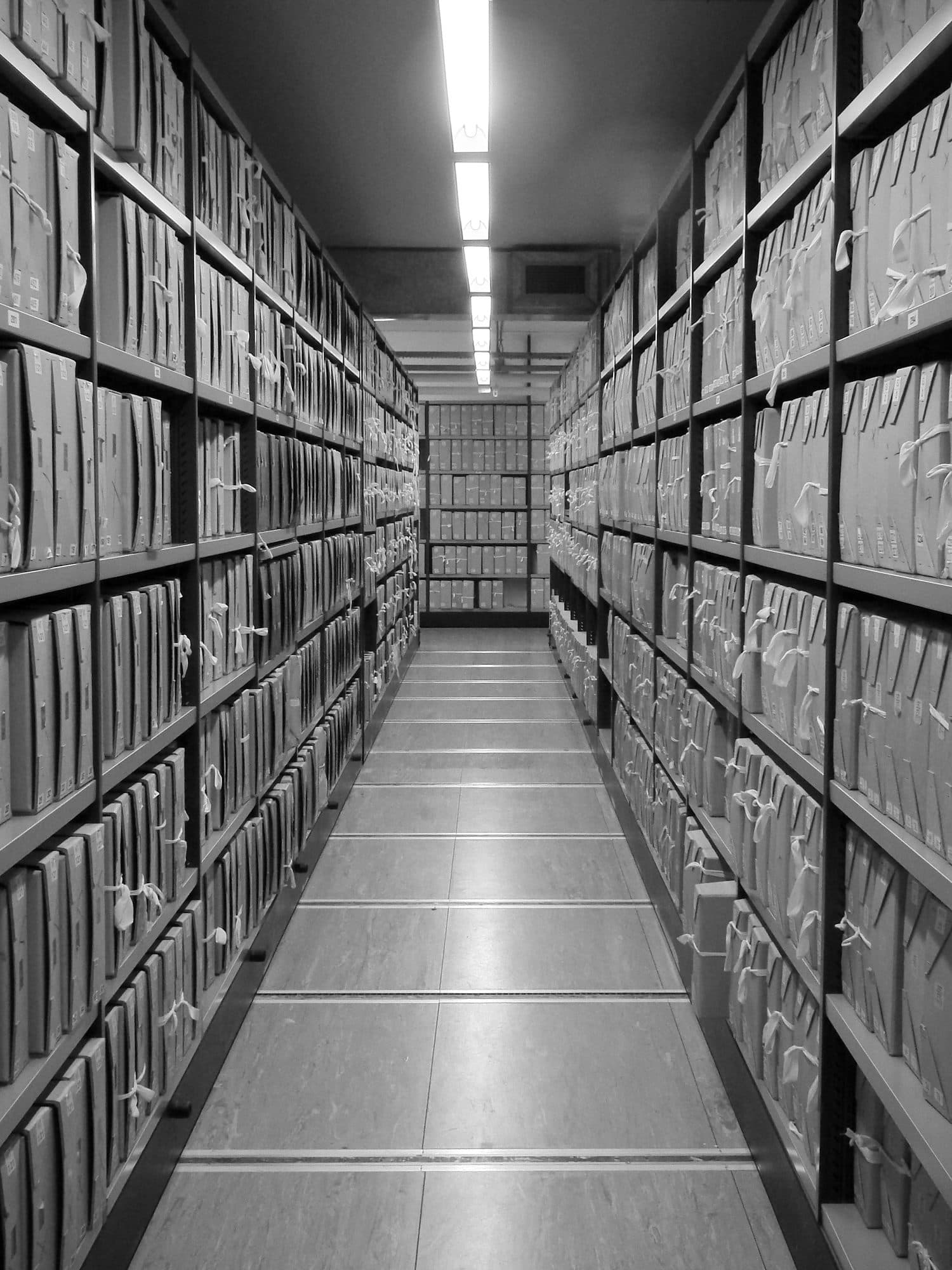 An aisle of boxed files at The National Archives, shelved floor to ceiling.